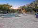 Spacious community pool area with lounge chairs, shade umbrellas, and a playground nearby at 121 Lindsay Ln # 31, Oldsmar, FL 34677