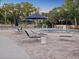 Relaxing community pool area with plenty of lounge chairs and shade umbrellas at 121 Lindsay Ln # 31, Oldsmar, FL 34677