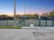 Outdoor tennis court featuring lighting, viewing pavilion, and perimeter fence for active recreation at 121 Lindsay Ln # 31, Oldsmar, FL 34677