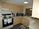 Galley kitchen with light wood cabinets and appliances at 4392 Craftsbury Dr, New Port Richey, FL 34652