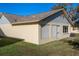 Rear view of house showcasing light beige vinyl siding and a grey roof at 4808 Vesper Ct, New Port Richey, FL 34655
