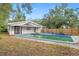 Aerial view of a backyard with a pool, wooden fence, and trees at 4939 18Th St, Zephyrhills, FL 33542