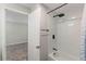 White tiled bathroom with a bathtub, shower, and black fixtures at 4939 18Th St, Zephyrhills, FL 33542