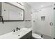 Modern bathroom with a glass shower, white subway tiles, and dark vanity at 4939 18Th St, Zephyrhills, FL 33542