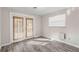 Bright bedroom with wood-look flooring, French doors, and blinds at 4939 18Th St, Zephyrhills, FL 33542