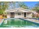 Exterior view of a house with a pool, covered patio area, and wooden fence at 4939 18Th St, Zephyrhills, FL 33542