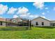 Backyard with a screened-in pool and lush green lawn at 591 Waterford W Cir, Tarpon Springs, FL 34688