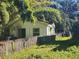 Small house exterior with overgrown yard and fence at 7222 N Ola Ave, Tampa, FL 33604