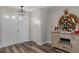 Light and bright entry with wood-look flooring, decorative console table, and a festive Christmas tree at 7423 Woodhollow Rd, Spring Hill, FL 34606
