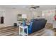 Relaxing living room featuring a navy blue reclining sofa and wood-look flooring at 7423 Woodhollow Rd, Spring Hill, FL 34606
