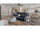 Spacious living room with a navy sectional sofa, wood-look floors, and view of the dining area at 7423 Woodhollow Rd, Spring Hill, FL 34606