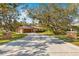Long concrete driveway leading to attached two-car garage and home entrance at 7443 Oak Tree Ln, Spring Hill, FL 34607