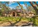 Beautiful single-story home with an arched entryway, nestled among mature trees at 7443 Oak Tree Ln, Spring Hill, FL 34607