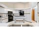 Kitchen with white cabinets, black appliances, and island counter at 7443 Oak Tree Ln, Spring Hill, FL 34607