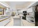 Spacious kitchen with white cabinets, black appliances, breakfast bar, and eat-in area at 7443 Oak Tree Ln, Spring Hill, FL 34607