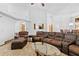 Spacious living room featuring vaulted ceilings, a fireplace, and brown leather furniture at 7443 Oak Tree Ln, Spring Hill, FL 34607