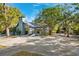Charming single-story home with a spacious driveway, mature trees, and a cozy front porch at 7600 138Th St, Seminole, FL 33776