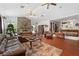 Bright living room featuring a stone fireplace, terracotta-tiled floors, and ample seating with a pool table in the background at 7600 138Th St, Seminole, FL 33776