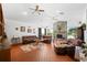 Spacious living room with a stone fireplace, ceiling fans, and comfortable leather furniture on a terracotta-tiled floor at 7600 138Th St, Seminole, FL 33776