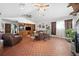 Open living room showcasing terracotta-tiled flooring, built-in shelves, and comfortable seating with plenty of natural light at 7600 138Th St, Seminole, FL 33776
