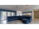 Open concept living area featuring a blue sectional sofa and adjacent kitchen at 8105 Shalom Dr, Spring Hill, FL 34606