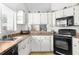 Well equipped kitchen with white cabinets and black appliances at 8190 Sturbridge Ct, Weeki Wachee, FL 34613