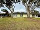 Home exterior showing backyard with grass and mature trees at 8704 Winding Wood Dr, Port Richey, FL 34668