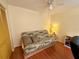 This is a casual bedroom with a futon, ceiling fan, and a small desk for versatility and comfort at 8704 Winding Wood Dr, Port Richey, FL 34668