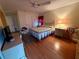 Comfortable bedroom with ceiling fan, laminate flooring, and a desk area; perfect for relaxation and productivity at 8704 Winding Wood Dr, Port Richey, FL 34668