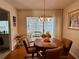 Cozy dining area with wood floors and a sunroom, perfect for enjoying meals and entertaining guests at 8704 Winding Wood Dr, Port Richey, FL 34668