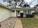House entrance with walkway, landscaping, and light-colored exterior at 8704 Winding Wood Dr, Port Richey, FL 34668