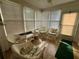 Bright sunroom featuring tile floor, large windows, and white wicker furniture at 8704 Winding Wood Dr, Port Richey, FL 34668