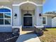 Elegant front entry with arched portico, double doors, stone accents, and charming lanterns at 1130 Aladdin Rd, Spring Hill, FL 34609