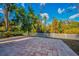 Paved patio and white fence in backyard, overlooking trees at 11645 Belle Haven Dr, New Port Richey, FL 34654