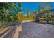 Backyard featuring a spacious brick patio, white fence, and screened-in pool area, ideal for outdoor activities at 11645 Belle Haven Dr, New Port Richey, FL 34654