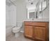 Clean bathroom with wooden vanity, toilet, and shower/tub combo at 11645 Belle Haven Dr, New Port Richey, FL 34654