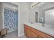 Bathroom with double vanity, whimsical shower curtain, and tiled flooring at 11645 Belle Haven Dr, New Port Richey, FL 34654