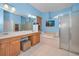 Bright bathroom featuring double sinks, a soaking tub, and a separate glass enclosed shower at 11645 Belle Haven Dr, New Port Richey, FL 34654