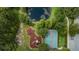 Aerial view of a community park with a playground, tennis/basketball court, and a pond at 11645 Belle Haven Dr, New Port Richey, FL 34654