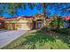 Charming single-story home with red tile roof, yellow stucco, stone accents, and a well-maintained lawn at 11645 Belle Haven Dr, New Port Richey, FL 34654