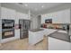 Modern kitchen with white cabinets, stainless steel appliances, an island, and tile flooring for a clean and functional space at 11645 Belle Haven Dr, New Port Richey, FL 34654