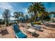 Poolside lounge area with chairs, umbrellas, and a view of the lake at 11645 Belle Haven Dr, New Port Richey, FL 34654
