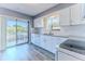 Kitchen with white cabinets, granite countertops and view to balcony at 12814 Wedgewood Way # C, Hudson, FL 34667