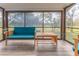 Relaxing screened porch with teal couch and wooden coffee table at 12814 Wedgewood Way # C, Hudson, FL 34667