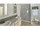 Modern bathroom with double vanity, glass shower, and tiled floor at 14287 Rialto Ave, Brooksville, FL 34613