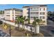 Exterior view of Port Bellaire condo community featuring lush landscaping and building entry at 155 Bluff View Dr # 103, Belleair Bluffs, FL 33770
