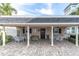 Covered patio area with tables near pool at 155 Bluff View Dr # 103, Belleair Bluffs, FL 33770