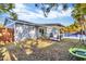 Spacious backyard featuring a covered wooden patio, inground pool, and lush greenery at 15950 Adobe Dr, Hudson, FL 34667