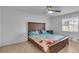 Inviting bedroom with a wooden bedframe, beach-themed bedding, and a ceiling fan at 15950 Adobe Dr, Hudson, FL 34667