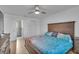 Main bedroom featuring a comfortable bed, wood flooring, ceiling fan, and an ensuite bathroom at 15950 Adobe Dr, Hudson, FL 34667